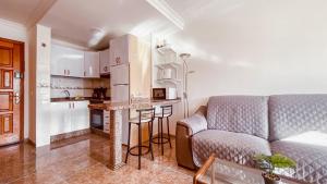a living room with a couch and a kitchen at La Orilla in San Agustin +30 photos