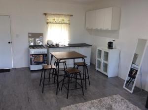a kitchen with a table and some stools in it at Ilaisaane Secured Budget Flat in Nuku‘alofa