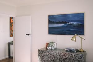 a painting on a wall above a dresser in a room at Bay Properties The Lookout in Yamba