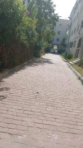 a brick road with trees on the side of a building at Appartement Familial Proche Aeroport Bab Andalous Tanger in Tangier +2 photos