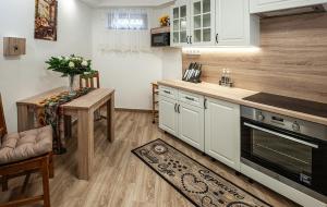 a kitchen with white cabinets and a table with a vase of flowers at Sunrise Airport Inn - Free Parking in Budapest +34 photos