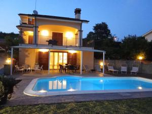 a villa with a swimming pool in front of a house at Villa Panorama Pool & Garden in Trevignano Romano