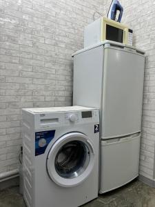 a washing machine sitting next to a brick wall at 1 комнатная квартира видом на горы in Almaty