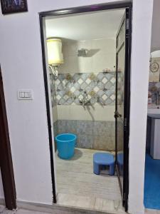 Un baño con puerta de cristal y un taburete azul. en Tara Home Stay, en Udaipur 32 fotos más