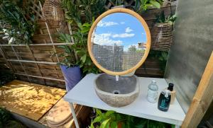 a bathroom sink with a mirror on a table at Panorama Beach Gartenhaus am SEE, Wiener Neustadt, Autark in Wiener Neustadt
