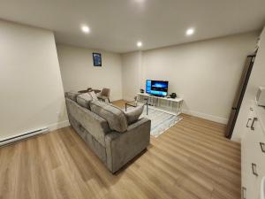 a living room with a couch and a television at Peace Abode in Dieppe