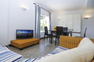 a living room with a couch and a tv and a table at Casa CODOLAR in Salou