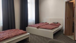 two twin beds in a room with a mirror at Penzion TGM in Příbram