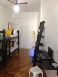 a room with bunk beds and a desk with a laptop at Méier House in Rio de Janeiro