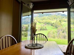 a table with a vase with flowers on it in front of a window at Appt 4 pers, pied des pistes in Flumet