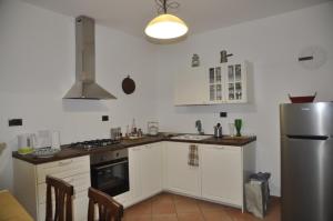 a kitchen with white cabinets and a stainless steel refrigerator at La casa sull'archetto in Corciano