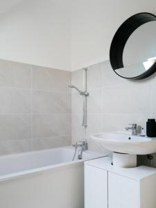 a white bathroom with a sink and a mirror at Maison refaite à neuf- avec Jacuzzi- LE HOMARD 15 in Perros-Guirec