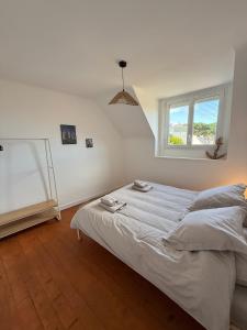 a white bedroom with a bed and a window at Maison refaite à neuf- avec Jacuzzi- LE HOMARD 15 in Perros-Guirec