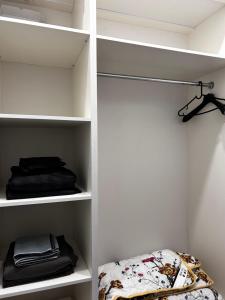 a walk in closet with white shelving at Квартира in Almaty