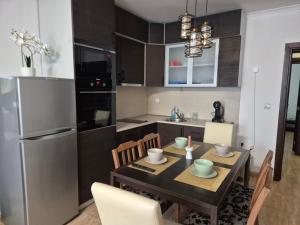 a kitchen with a table with chairs and a refrigerator at 1А1 Apartament in Pamporovo