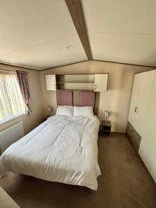 Un dormitorio con una gran cama blanca. en Seaview Holiday Rentals - ABI Oakley, en Chestfield