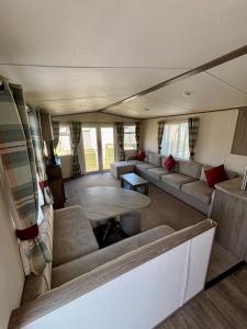 Una sala de estar con sofás y una mesa en un remolque. en Seaview Holiday Rentals - ABI Oakley, en Chestfield