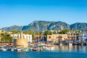 un grupo de barcos atracados en un puerto con montañas en Central Girne Escape by HolidayKeys, en Kyrenia