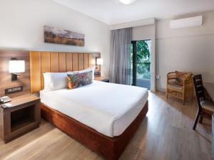 a bedroom with a bed and a desk and a chair at ANEW Hotel Hluhluwe in Hluhluwe