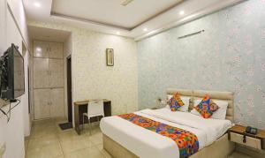 a bedroom with a bed and a desk and a television at FabHotel Comfirt Inn in Noida