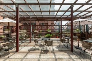 an outdoor patio with tables and chairs and umbrellas at Hotel G7 Taipei in Taipei