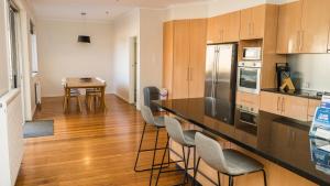 una cucina con bar, sedie e tavolo di Prime Location Private Home Large Pool Pets welcome a Glen Iris