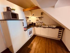a kitchen with white cabinets and a microwave at Ferienwohnung de lütte Leive in Born in Born