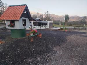una piccola casa con il tetto rosso su una strada sterrata di Bella montanha pousada e camping a Lauro Müller