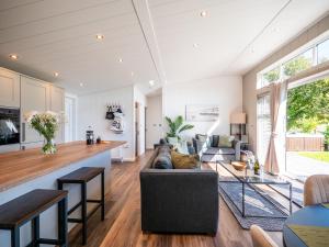 una sala de estar con un sofá y una mesa en Stylish 3-bed Lodge With Golf & Spa Access, en Hemborough Post