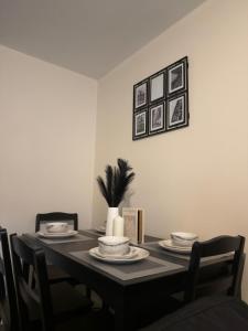 a dining room table with plates and a plant on it at Luxury 2-Bedroom Home 10 Minutes from Birmingham City Centre in Birmingham