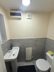 a bathroom with a white sink and a toilet at Luxury 2-Bedroom Home 10 Minutes from Birmingham City Centre in Birmingham