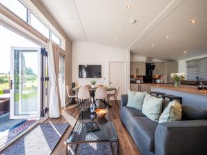 una sala de estar con un sofá y una mesa en Stylish 3-bed Lodge With Golf & Spa Access, en Hemborough Post