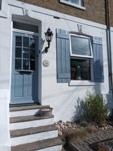 a house with a blue door and a window at Charmantes Cottage im Landhausstil in Kearsney, Dover 