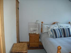 a bedroom with a bed and a table with a lamp at Charmantes Cottage im Landhausstil in Kearsney, Dover 