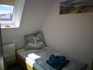 a small bed with blue towels on it in a room at Boddenkahn in Born
