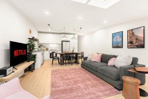 a living room with a couch and a kitchen at Richmond Royale walk to the MCG Swan St & Bridge Road in Melbourne +26 photos