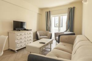 a living room with a couch and chairs and a tv at Lagos Center Apartment in Lagos