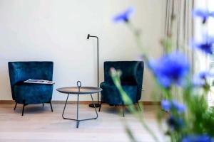 Dos sillas y una mesa en una habitación con flores azules en Luxury Nordic Villa with Private Sauna, en Karmøy