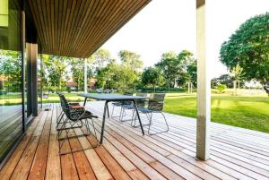 Un patio con una mesa y sillas en una terraza. en Luxury Nordic Villa with Private Sauna, en Karmøy
