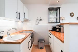 a white kitchen with a sink and a counter at Panoramic B03-1 in Sierksdorf +19 photos
