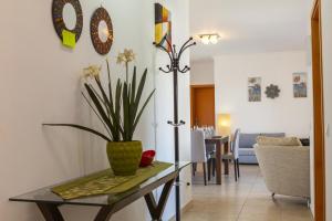 a dining room with a table with a plant on it at A68 - Palmeiras Paz Apartment in Lagos