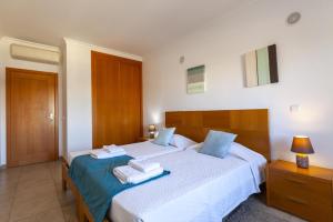 a bedroom with two beds with towels on them at A68 - Palmeiras Paz Apartment in Lagos +32 photos