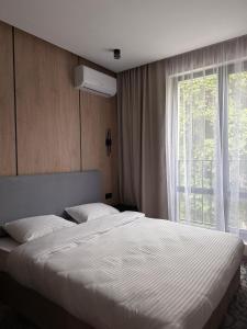 a bedroom with a large bed and a window at MILANIUM hotel in Almaty +17 photos