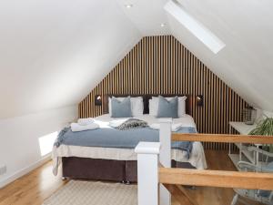 a bedroom with a bed with a wooden headboard at The Workshop in Tavistock