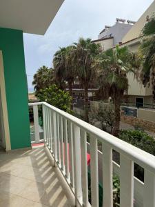 a balcony with a view of the ocean and palm trees at Estrela do Mar 6F in Santa Maria