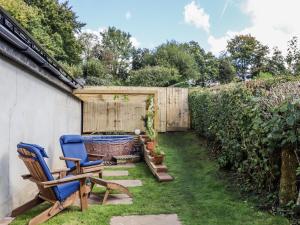 a garden with two chairs and a fence at The Workshop in Tavistock
