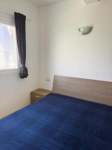 a bedroom with a blue bed and a window at Estrela do Mar 6F in Santa Maria