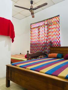 a bedroom with two beds and a ceiling at Jayawikrama Cafe and Guest in Matara