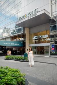 a woman is standing in front of a building at Four Points by Sheraton Bangkok Ploenchit Sukhumvit in Bangkok