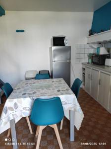 a kitchen with a table with chairs and a refrigerator at Maison de vacances individuelle toute équipée in Dampierre-sous-Bouhy +5 photos